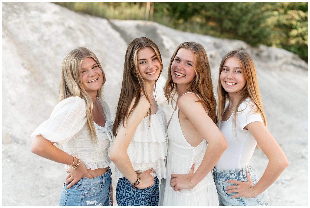 four senior girl spokesmodels facing each other with hands on hips wearing white tops and jeans at white cliffs of conoy