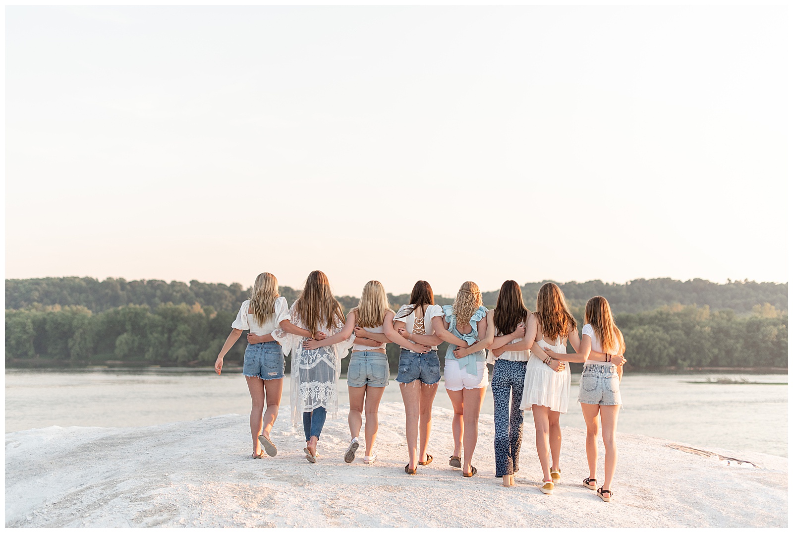 eight senior girls with their arms around each other and their backs toward the camera on sunny evening atop the white cliffs of conoy in lancaster pennsylvania