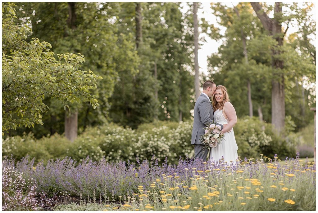 bride and groom standing among wildflowers on sunny day at elizabeth furnace in lititz pennsylvania