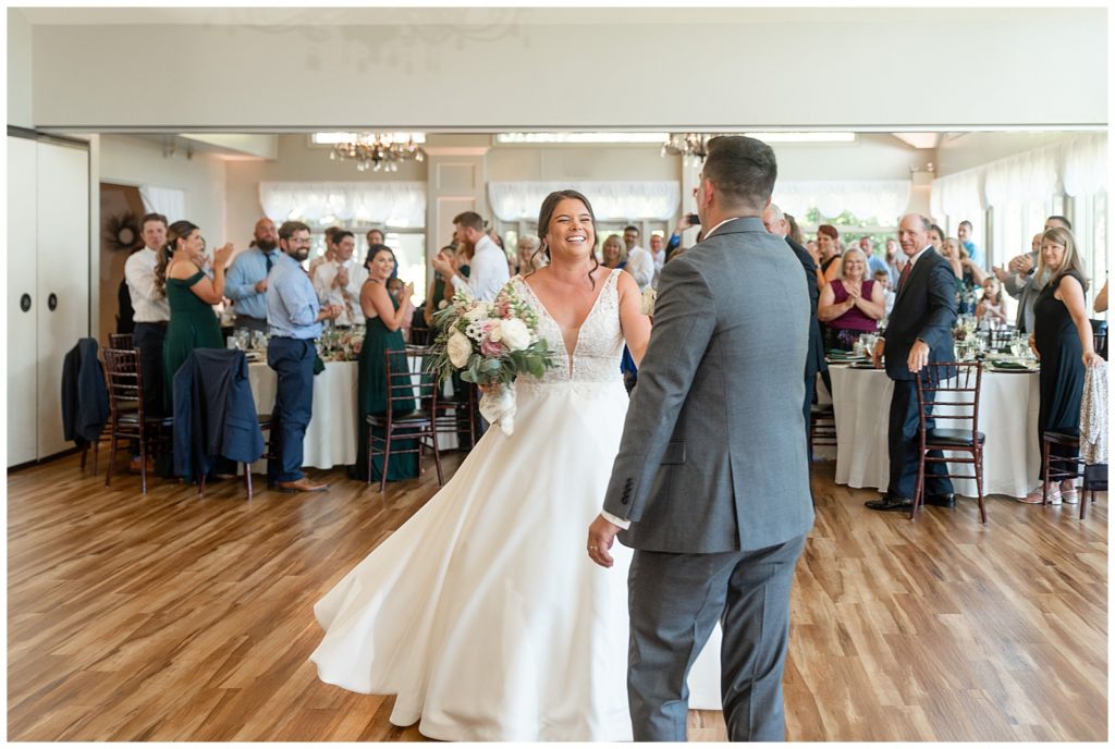 bride and groom dancing on the dance floor during their indoor reception surrounded by guests at the manor at mountain view