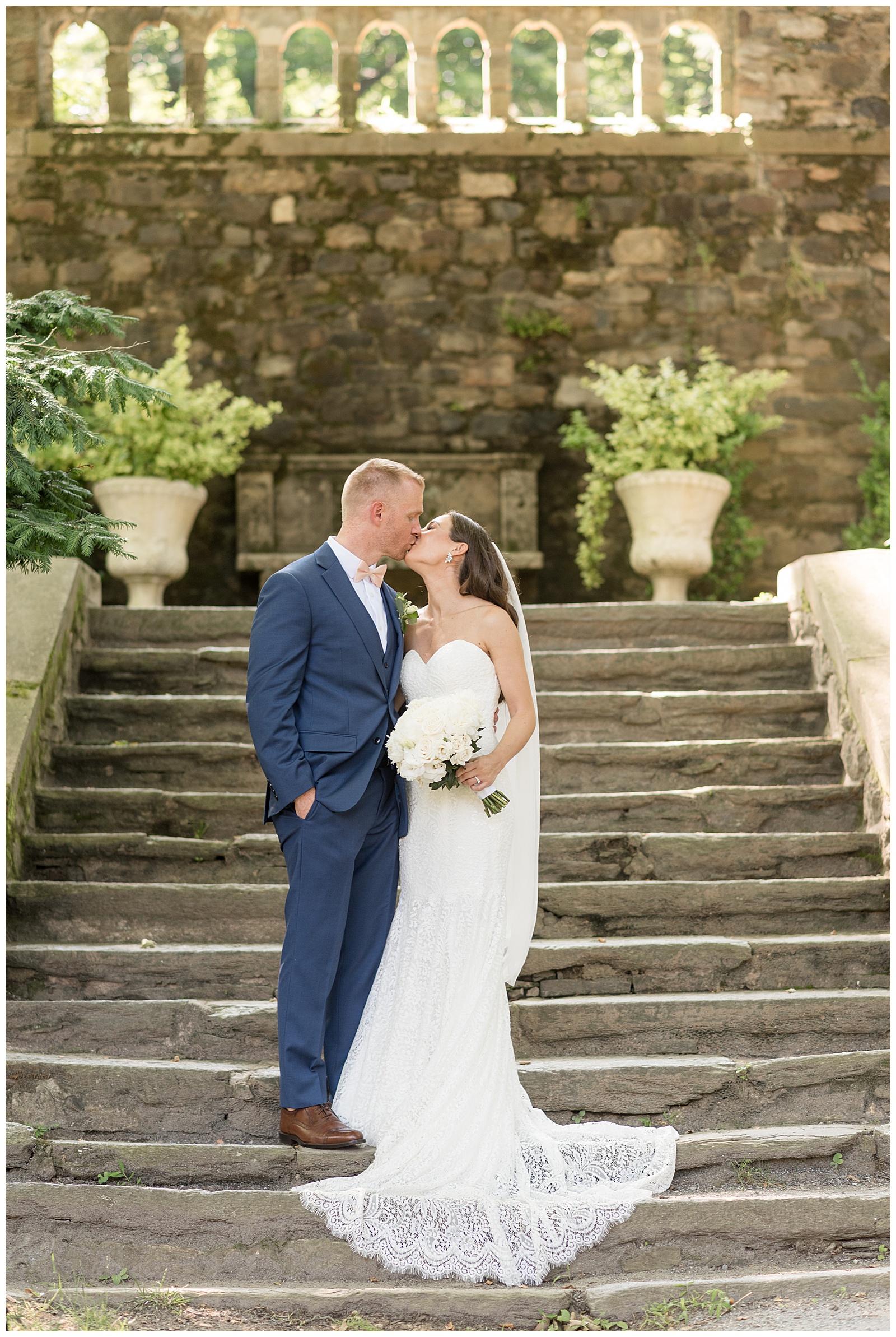 couple kissing at the bottom of stone steps at outdoor wedding at PARQUE Ridley Creek in glen mills pennsylvania