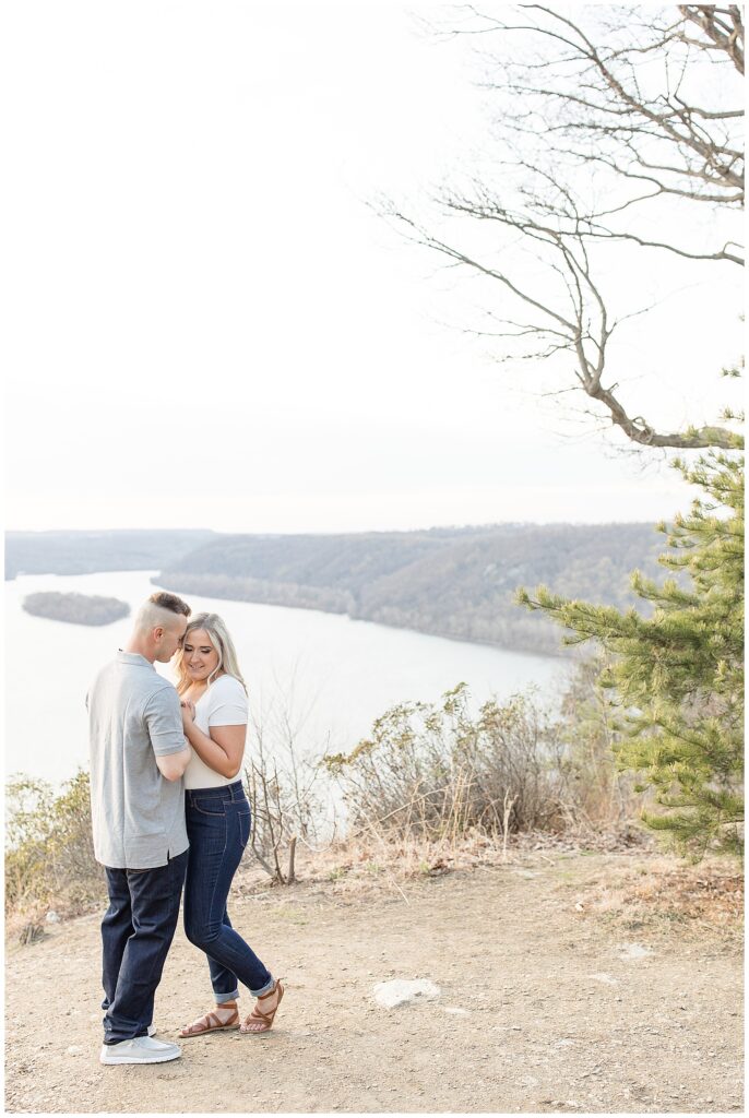 engaged couple standing close with foreheads touching atop pinnacle point overlook in holtwood pennsylvania