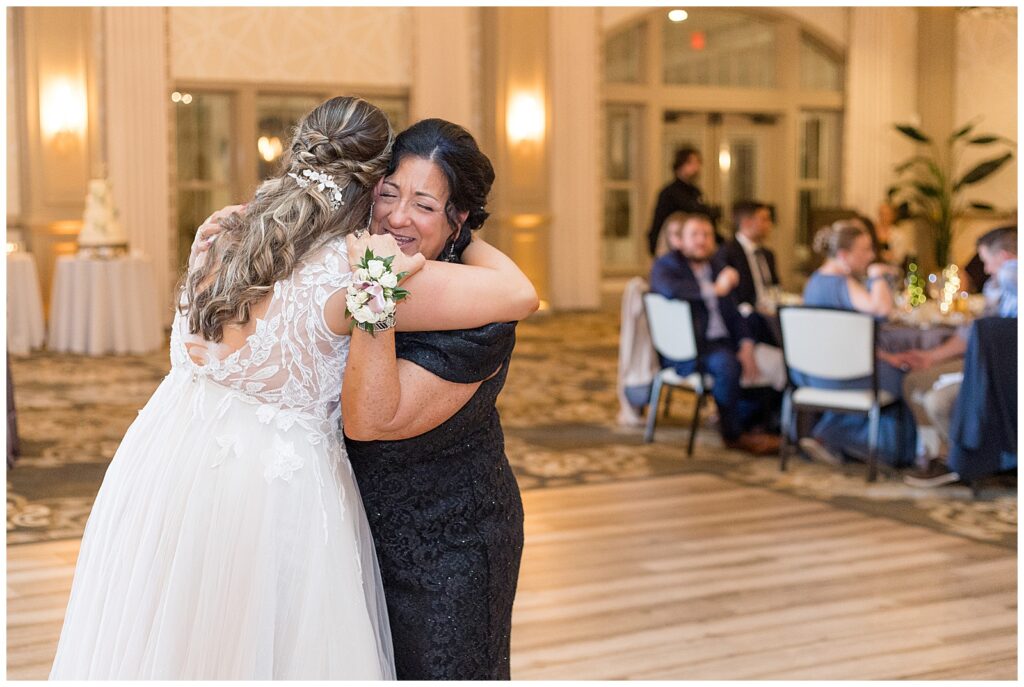 bride hugging her mother-in-law at reception after slow dance as guests watch at rivercrest golf club 