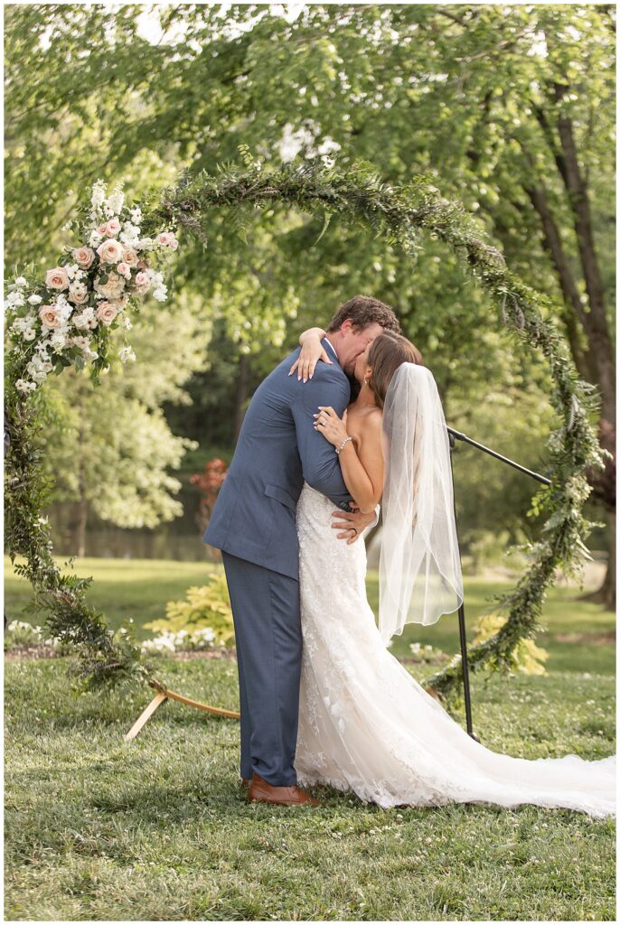 couple sharing their first kiss as husband and wife during outdoor ceremony at promise farm