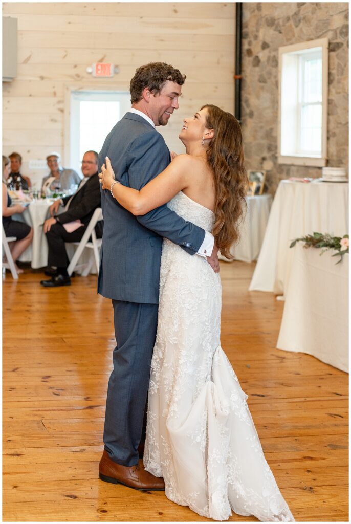 couple sharing their first dance during their indoor barn wedding reception at promise farm