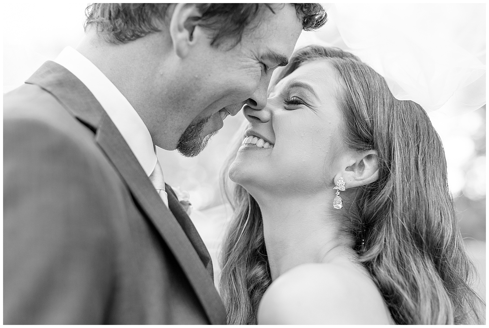 closeup black and white photo of couple smiling and almost kissing on wedding day at promise farm