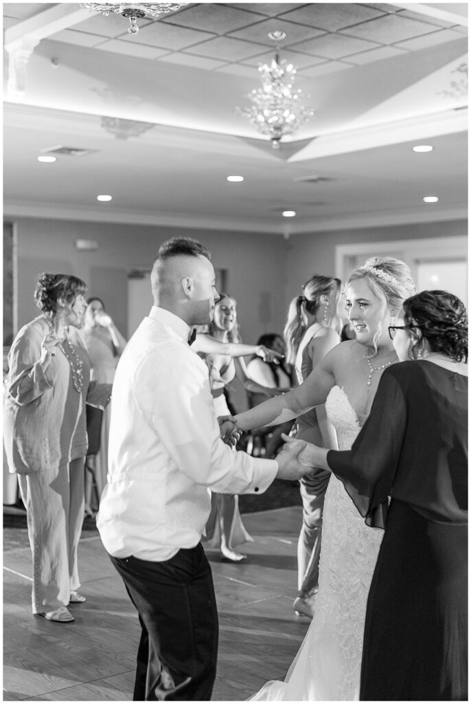 black and white photo of bride and groom dancing with guests during reception in bel air maryland at country club