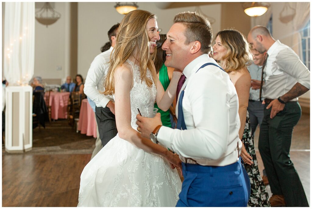 bride and groom dancing during indoor reception surrounded by guests at historic savage mill in maryland