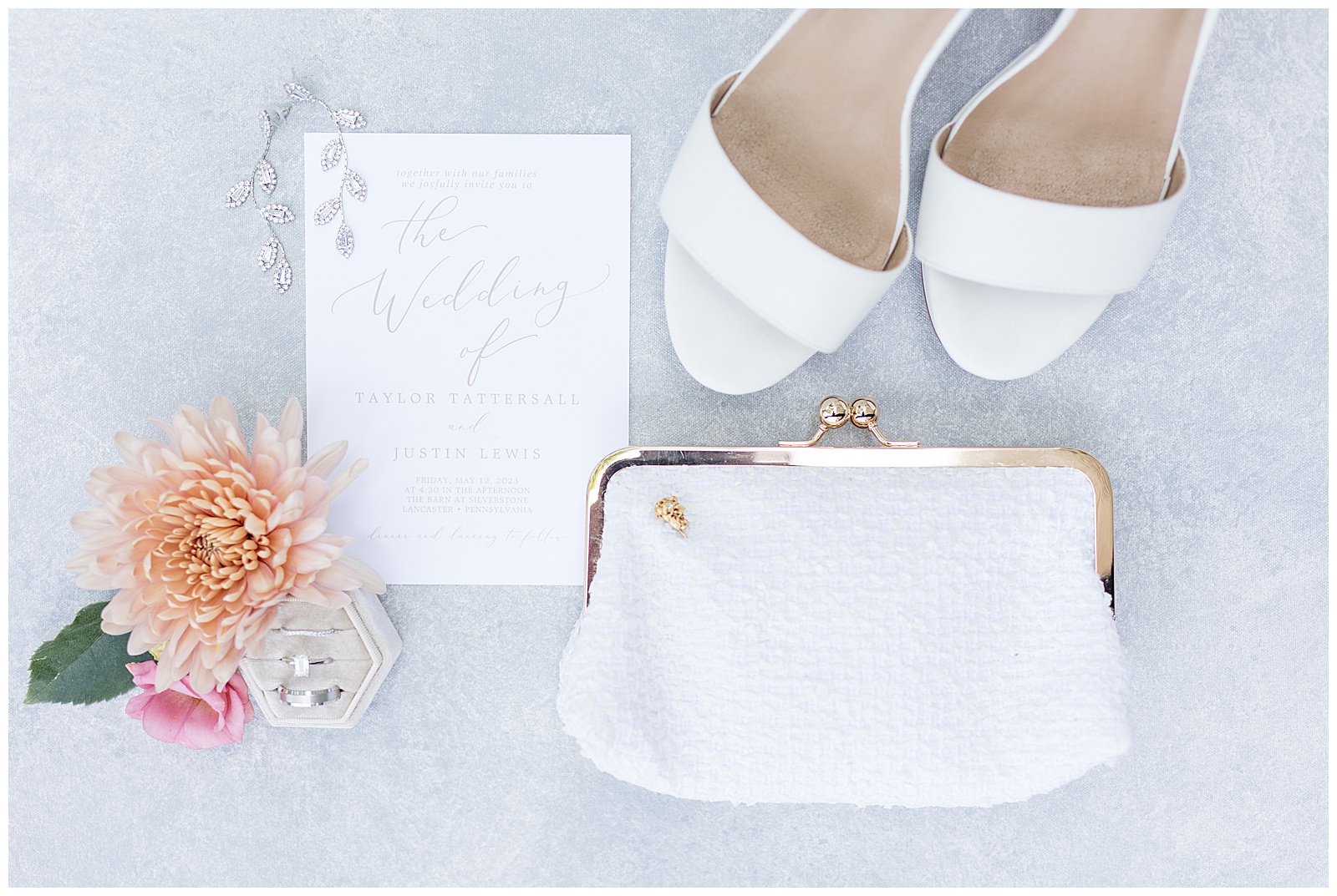 bride's white sandals and white clutch beside wedding invitation and bottle of perfume in lancaster county