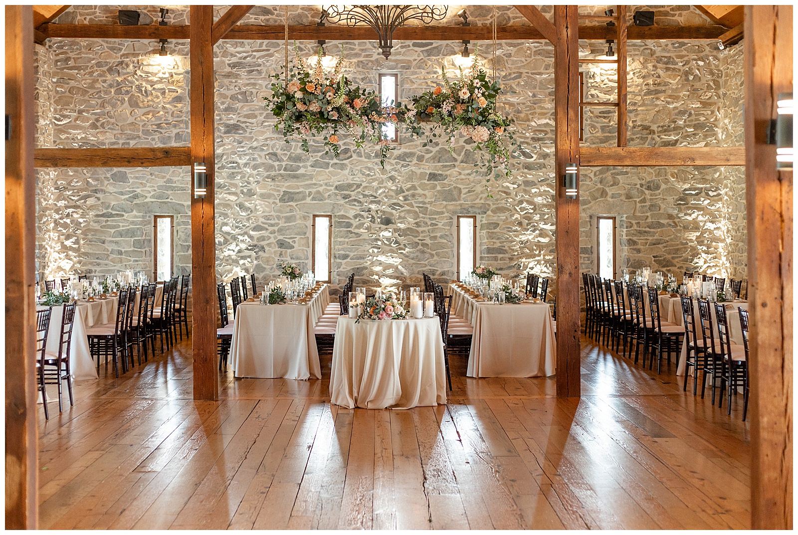 indoor barn wedding reception with exposed wooden beams and beautifully decorated tables at the barn at silverstone