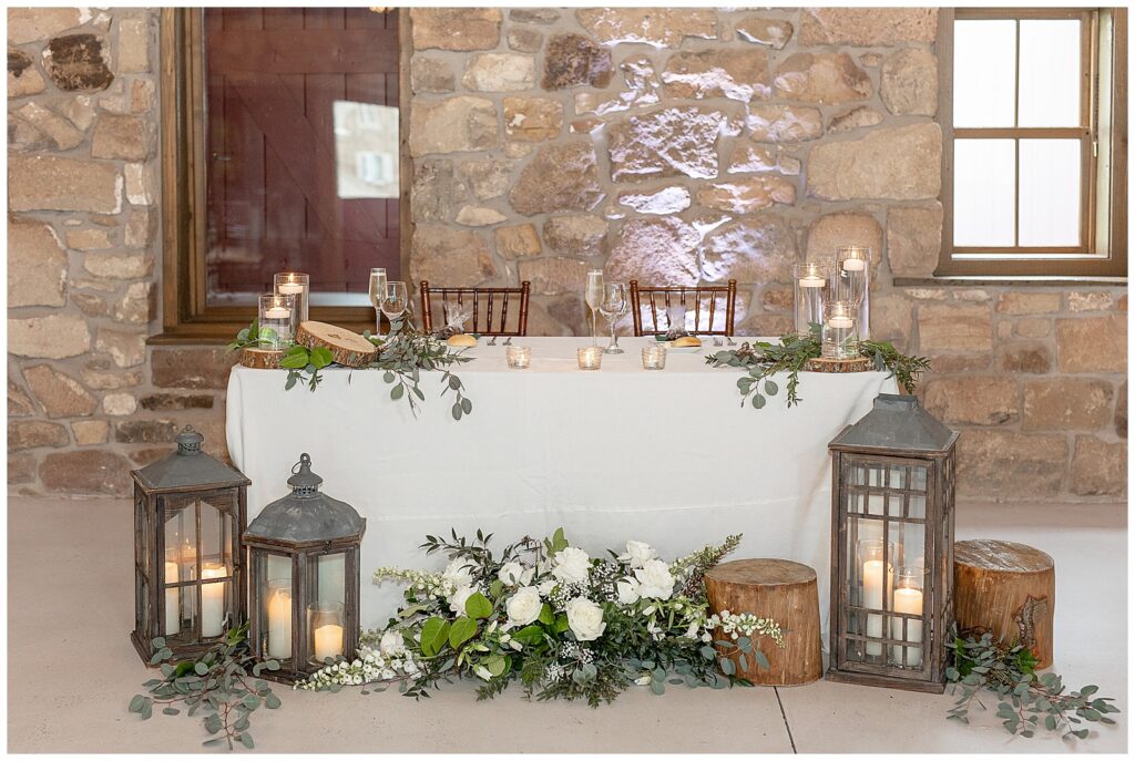 beautiful couples' table with wooden lanterns and floral displays at elizabeth furnace wedding venue in lititz pennsylvania