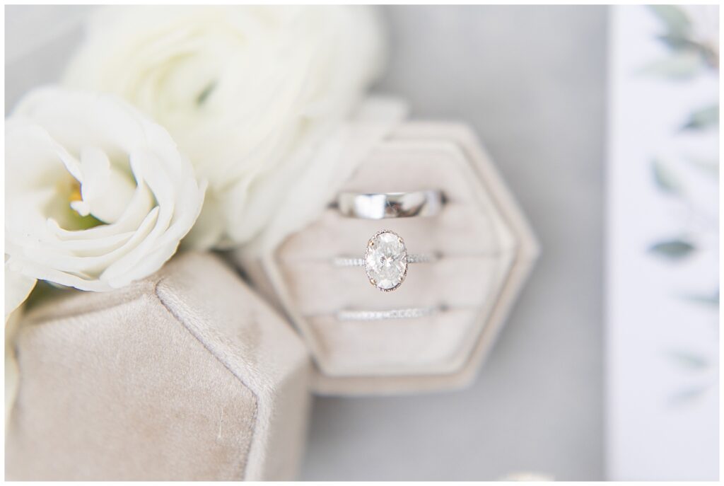 beautiful wedding rings displayed in ivory velvet box by white rose at historic ashland