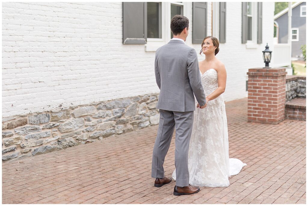 bride and groom share first look moment before wedding ceremony by historic york county building