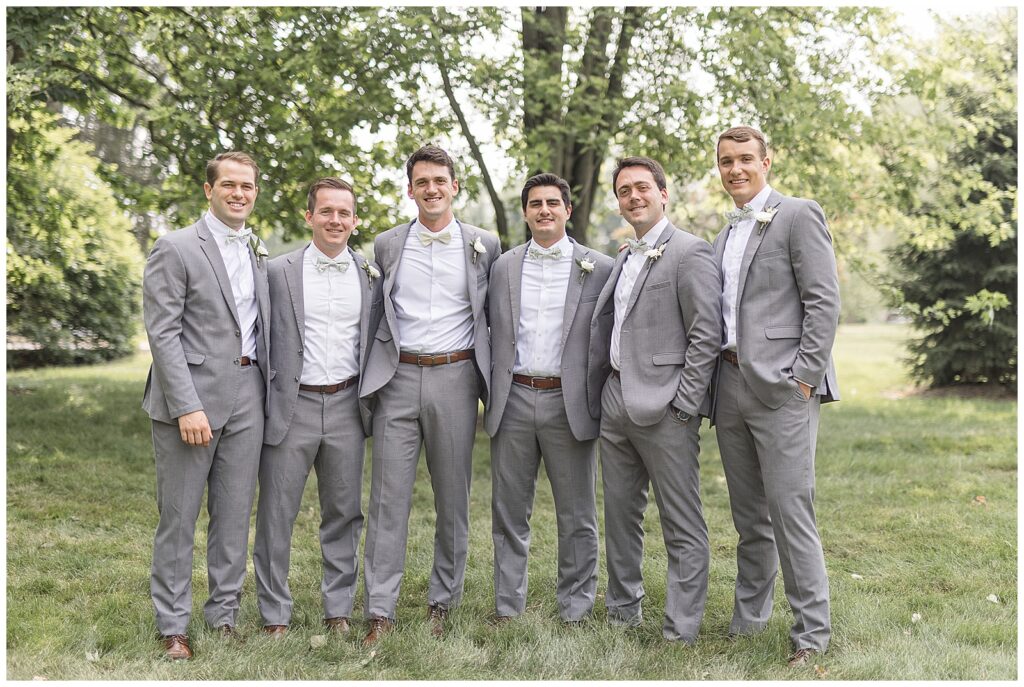 groom and five groomsmen all with their arms around one another outdoors at historic ashland