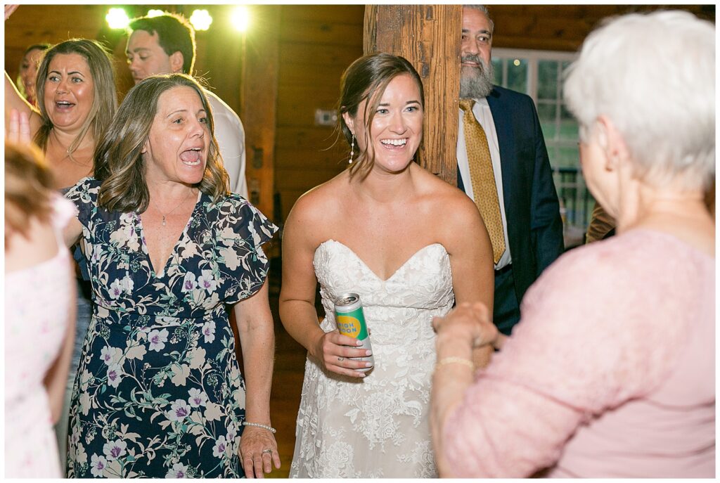 bride with her friends and grandma as they dance inside barn reception at historic ashland in york pennsylvania