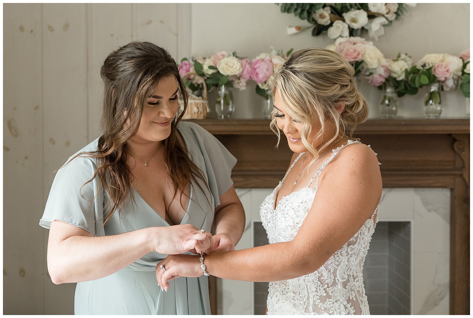 maid of honor helping bride with the clasp of her bracelet in bridal suite at barn venue in lancaster county pennsylvania
