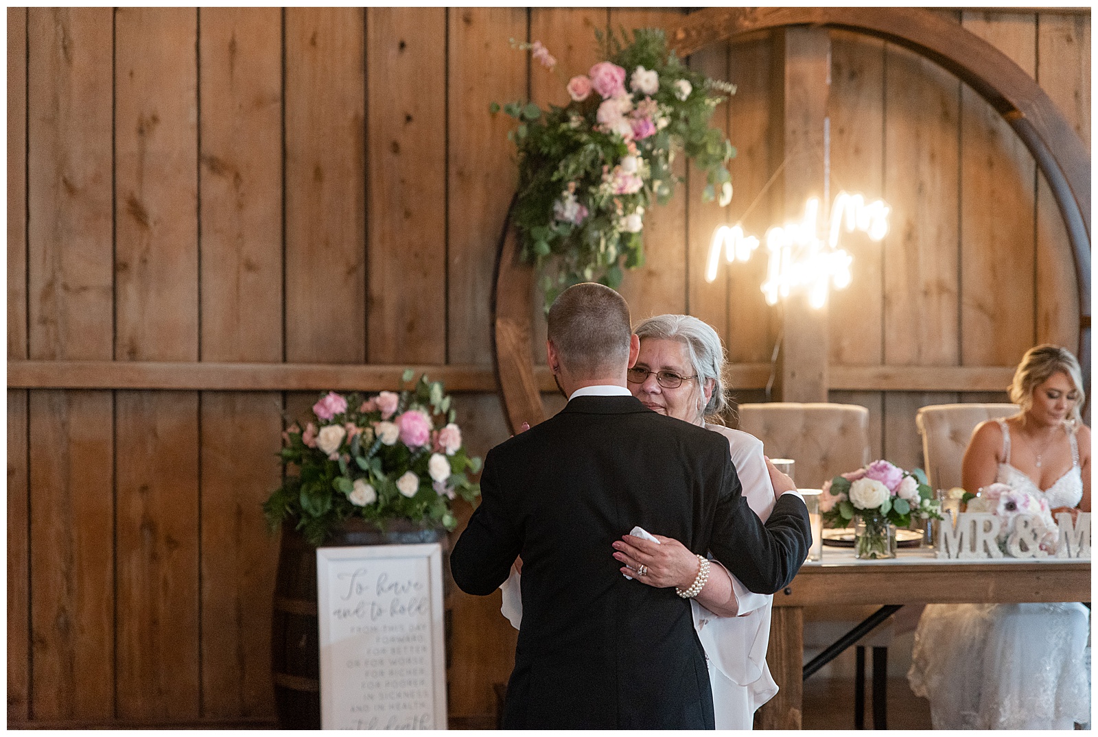 groom dancing with his mom with his back towards the camera inside barn reception at stoltzfus homestead