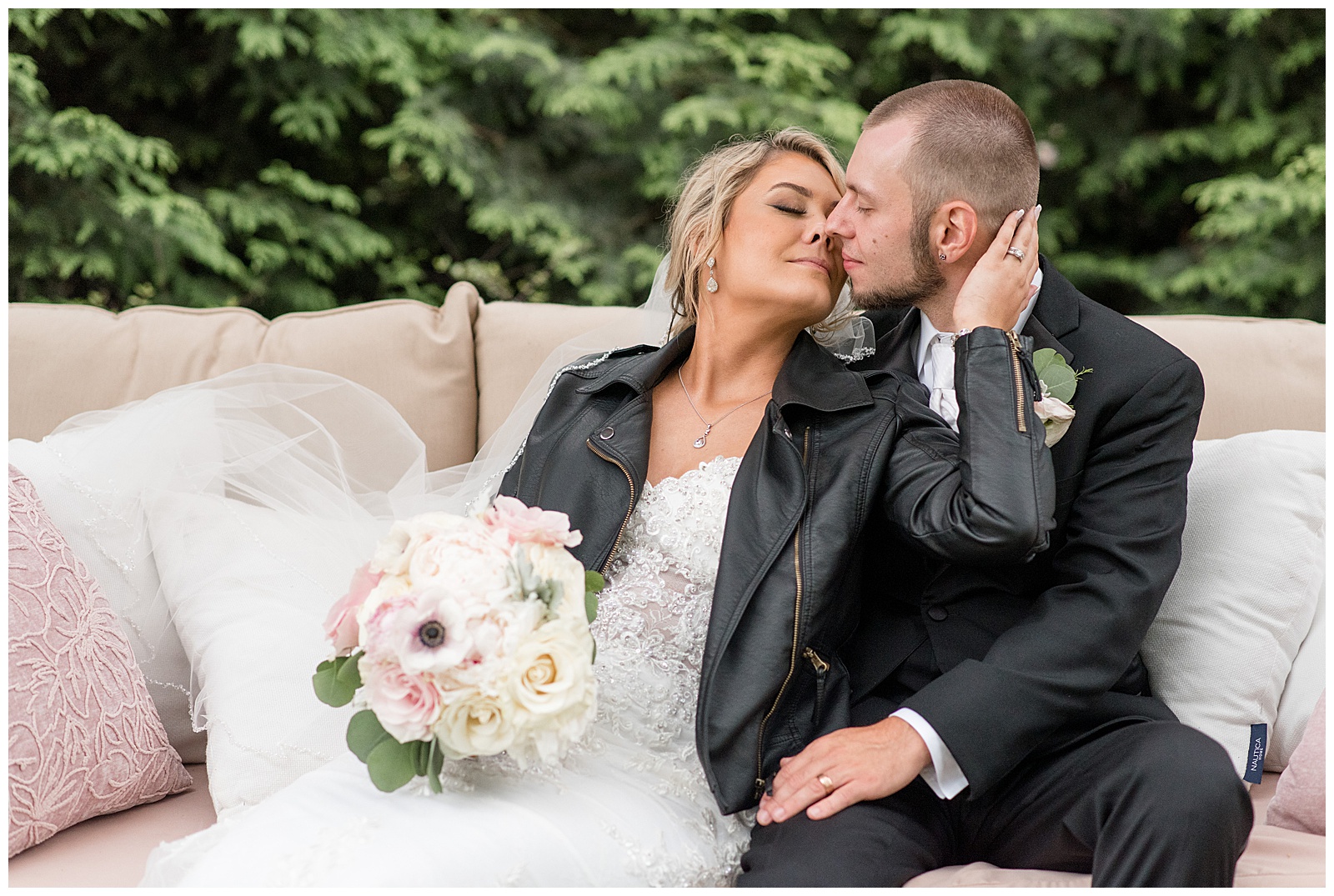 bride and groom sitting on swing almost kissing and bride has on black leather jacket at venue in intercourse pa