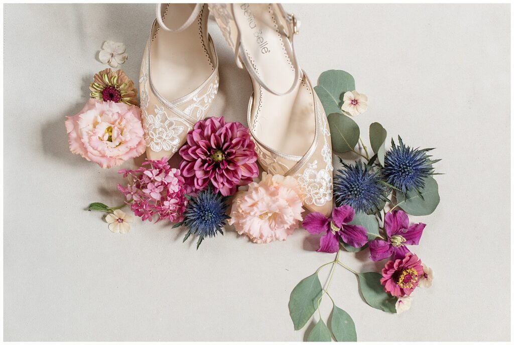 bride's ivory strappy heels surrounded by maroon, pink, and navy blue flowers in lancaster pa