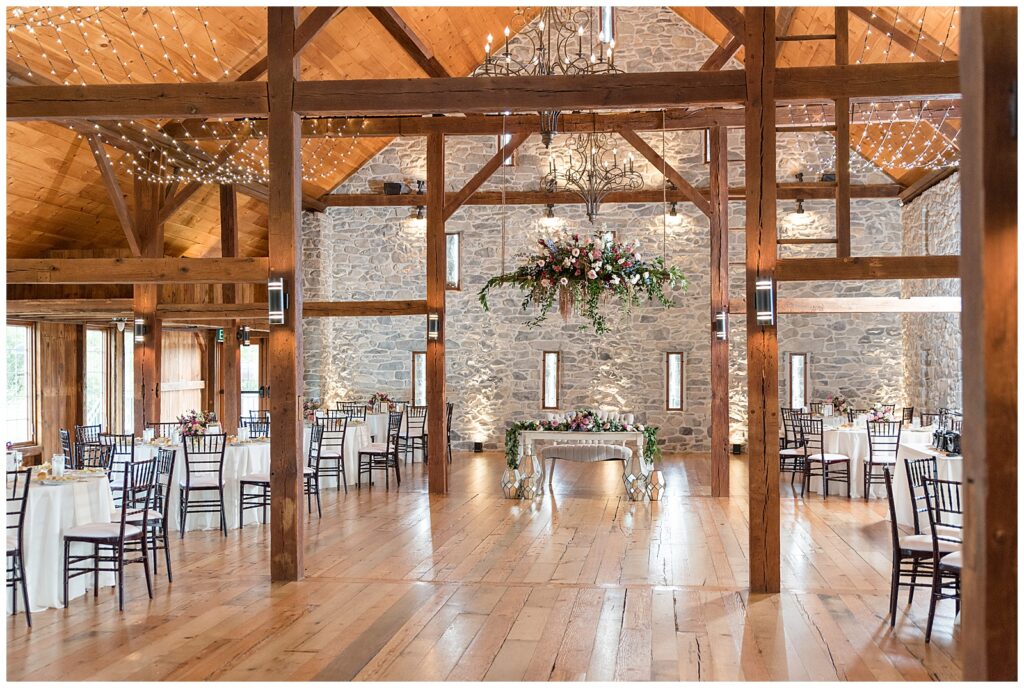 beautiful barn venue with exposed wood beams and lovely floral chandelier at the barn at silverstone