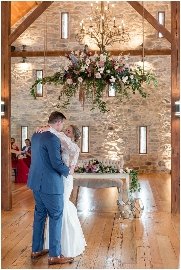 bride and groom dancing as they look at each other during first dance inside stone barn in lancaster county