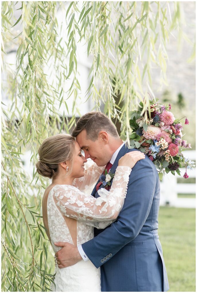 couple touching foreheads under willow tree at the barn at silverstone in lancaster county