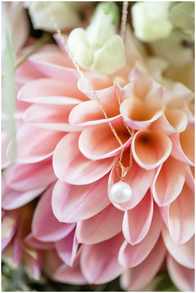 pearl necklace draped on multicolored pink dahlia at the barn at silverstone