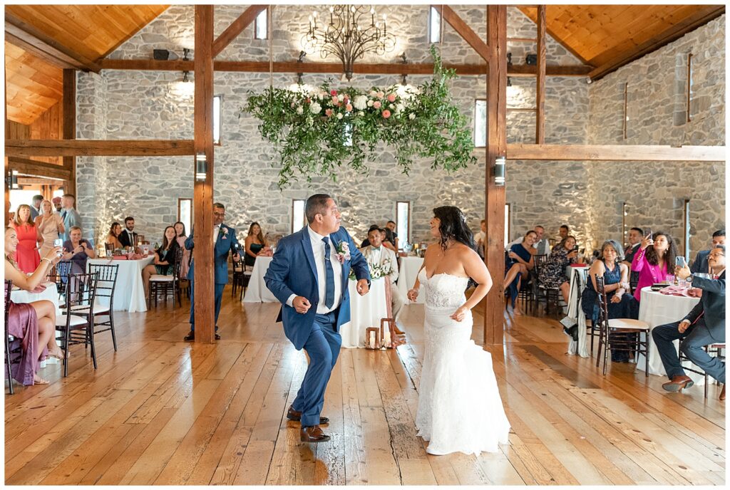 bride and her dad having fun dancing together during their barn wedding reception as guests watch at the barn at silverstone