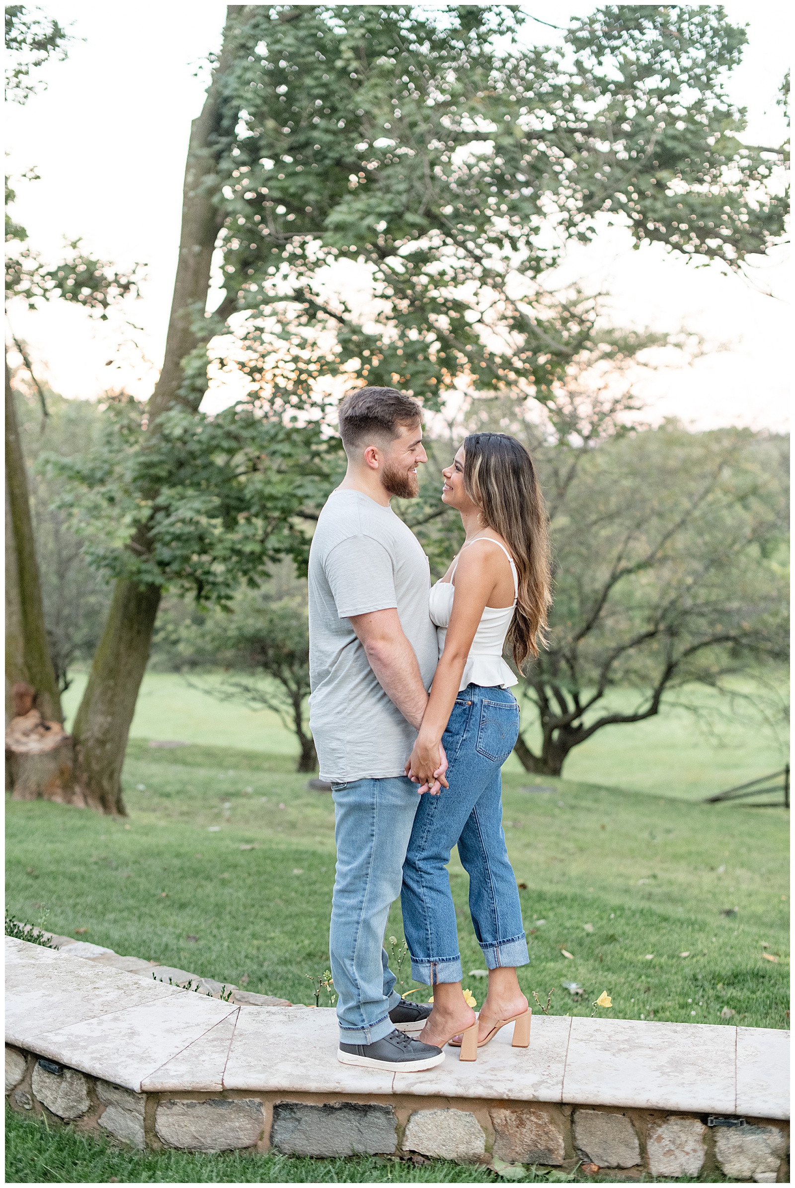 couple standing close holding hands at sunset with trees in background at Domaine Pterion
