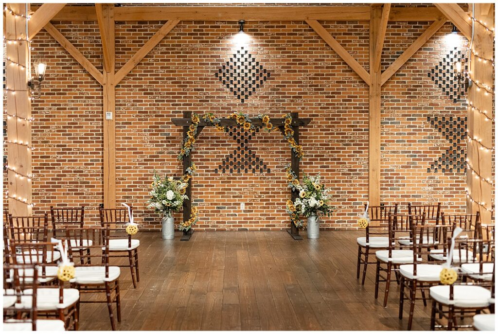 indoor wedding ceremony with brick wall and beautiful wooden display at brick gables in lititz pa