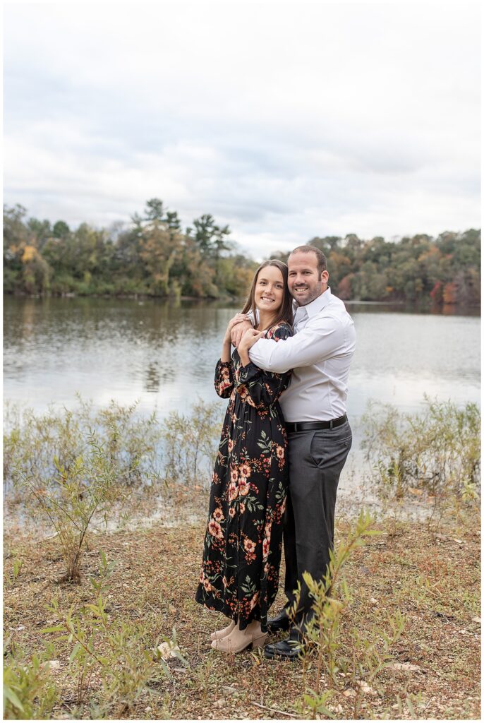 guy hugging girl from behind as they both smile at camera by lake in york pennsylvania