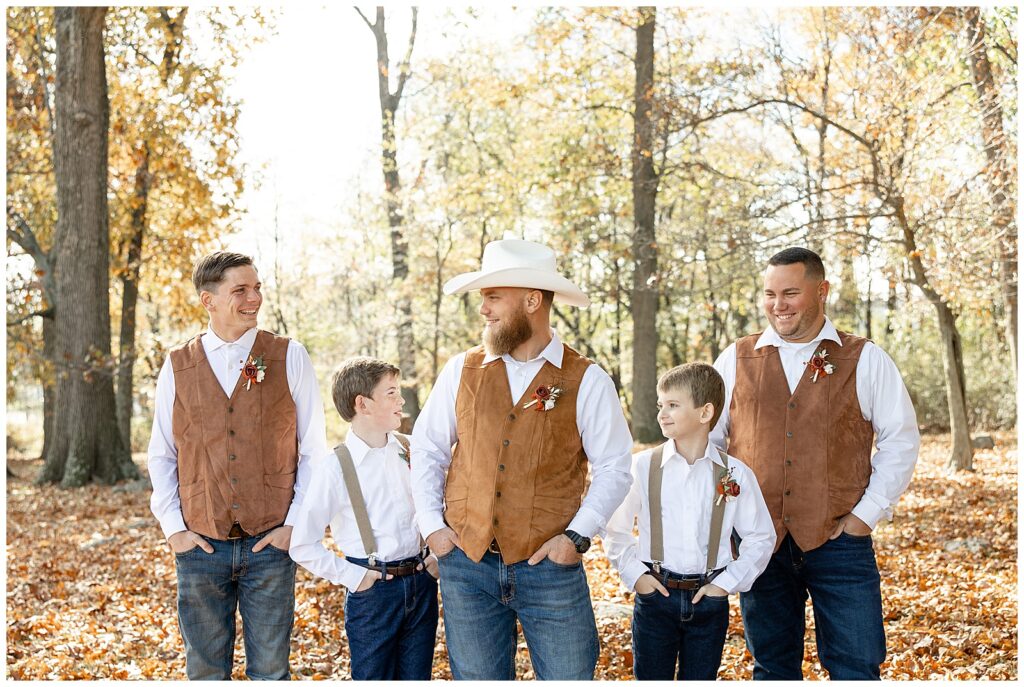 groom surrounded by his four groomsmen all wearing brown vests or suspenders in forest in wrightsville pennsylvania