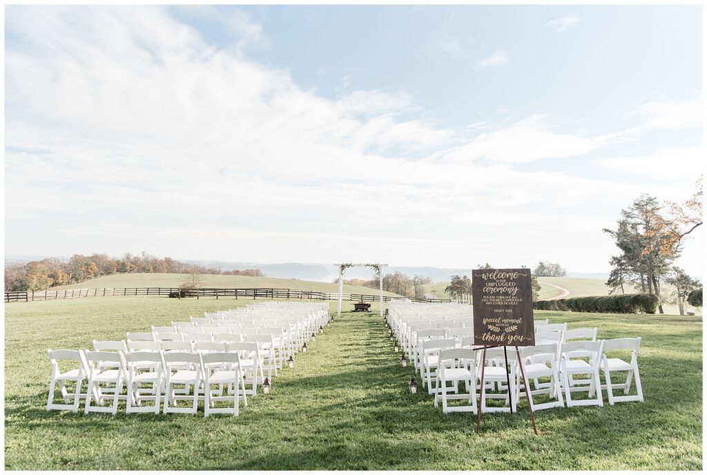 rows of white chairs set up facing arbor and the susquehanna river at lauxmont farms on sunny fall day