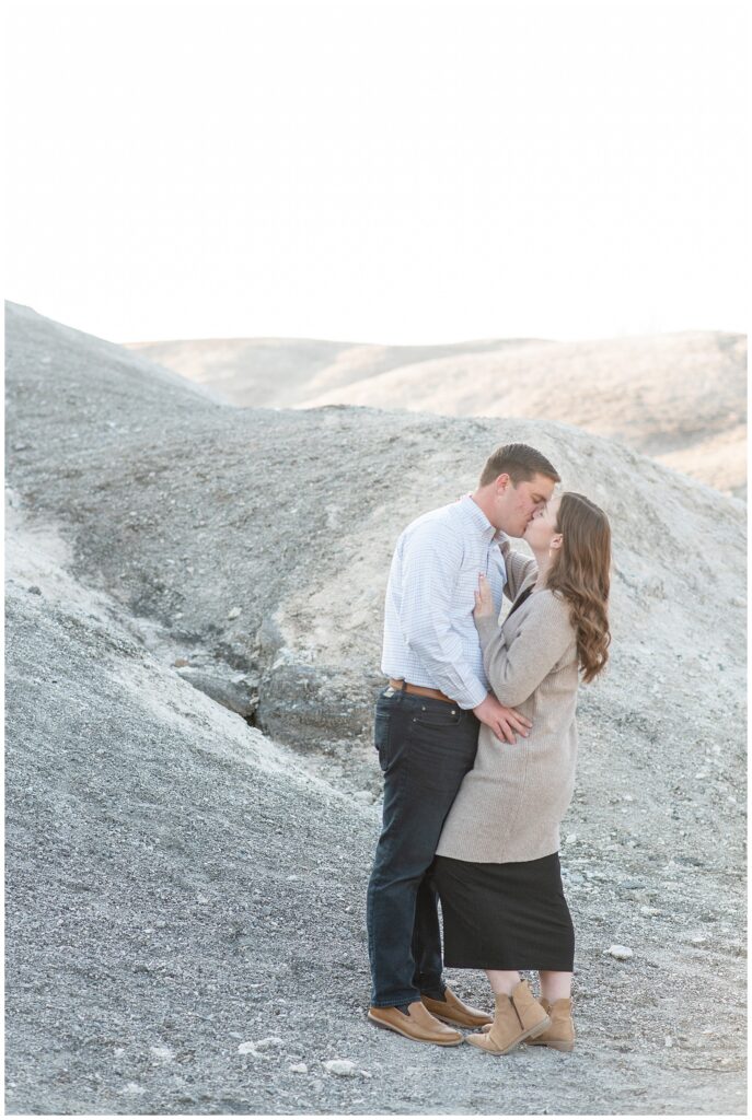 engaged couple hugging and kissing on the white cliffs of conoy in lancaster pennsylvania in winter