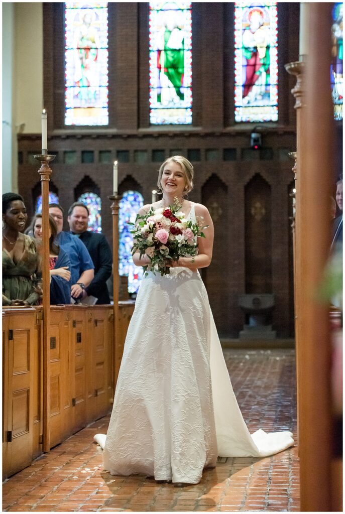 bride walking down the aisle of st. james episcopal church holding bouquet as guests watch in lancaster city