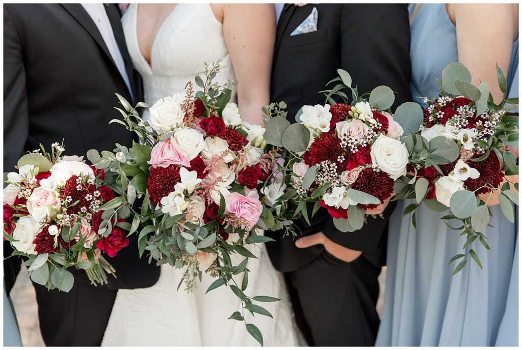 closeup photo of bride and bridesmaid holding bouquets as they stand by groom and groomsman in lancaster pa