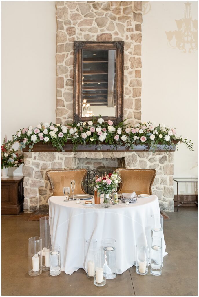 bride and groom's beautifully decorated table by stone fireplace at the inn at leola village