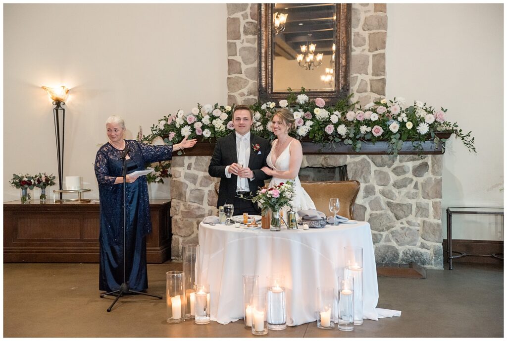 couple during toast with guest standing by their table during their reception at the inn at leola village