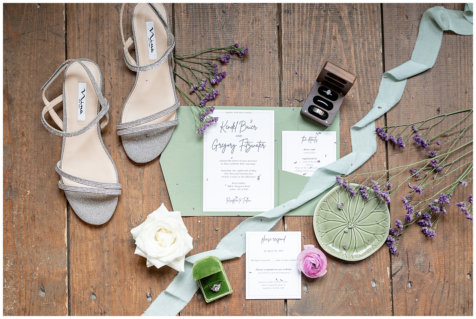 bridal details like invitation, ring boxes, bride's shoes and more on display on wood floor at brick gables