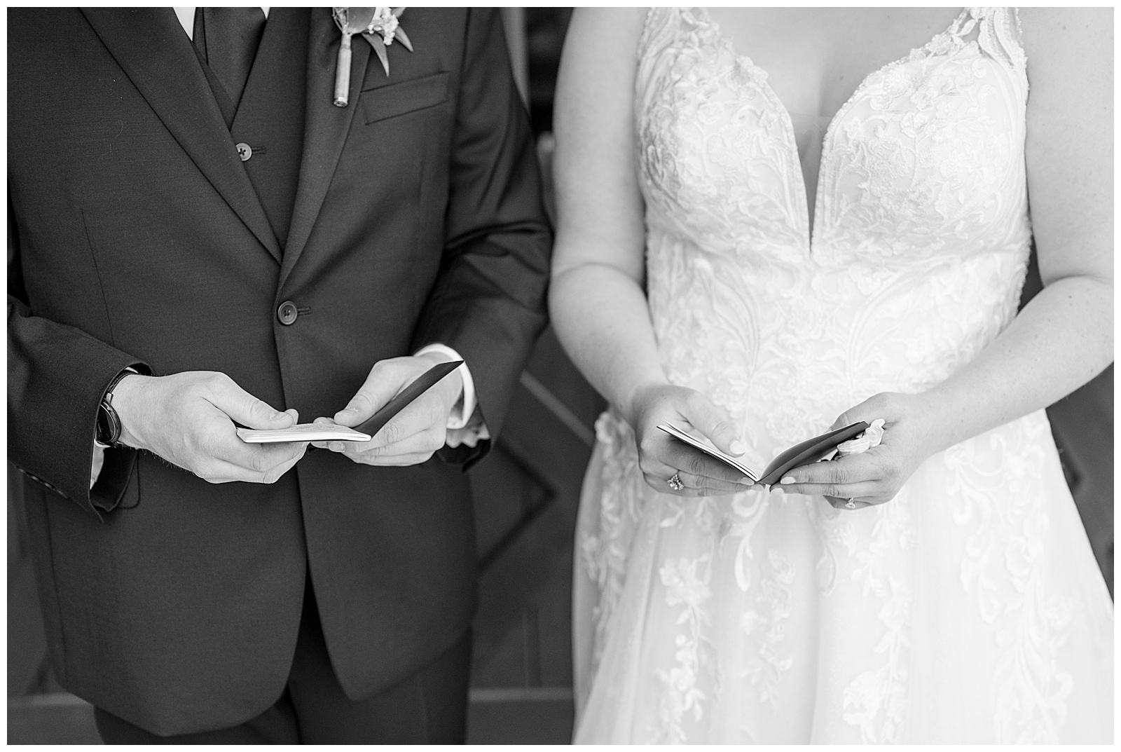 black and white closeup photo of bride and groom holding their booklets of wedding vowels before ceremony at brick gables