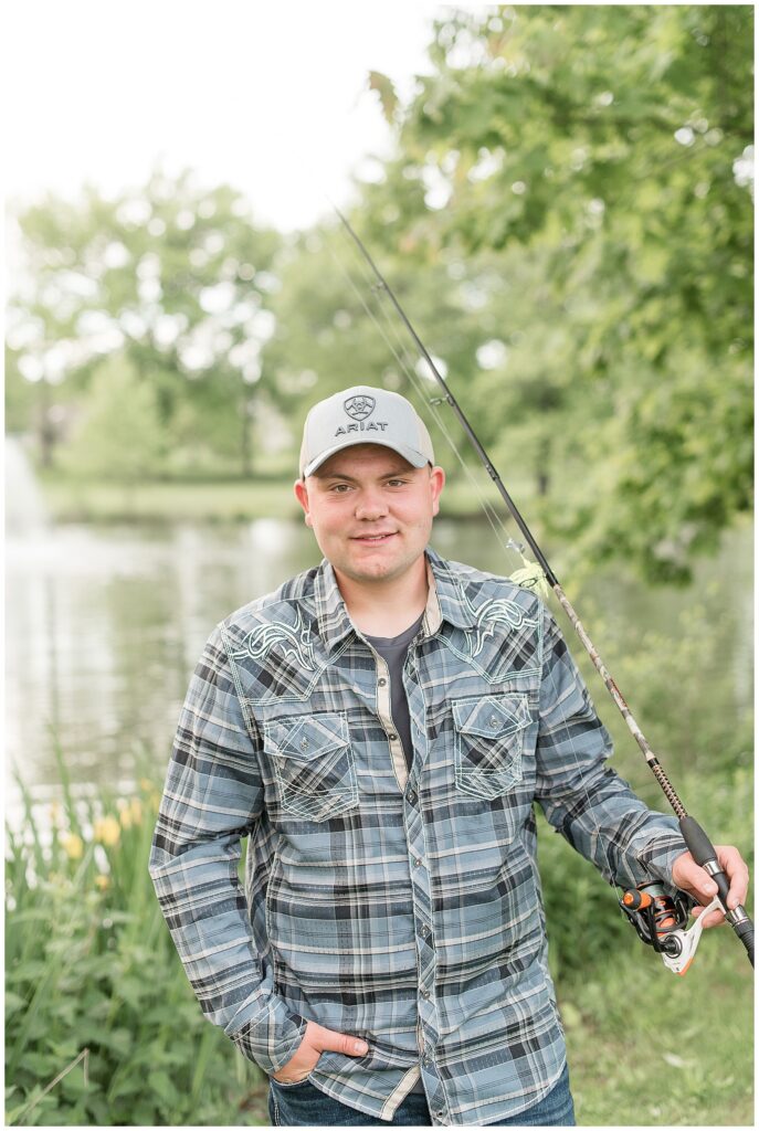 guy wearing blue and black flannel shirt holding fishing rod in his left hand by pond in elizabethtown pa