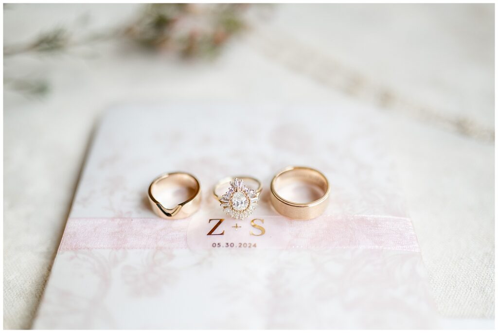 wedding rings displayed atop monogrammed book at domain pterion