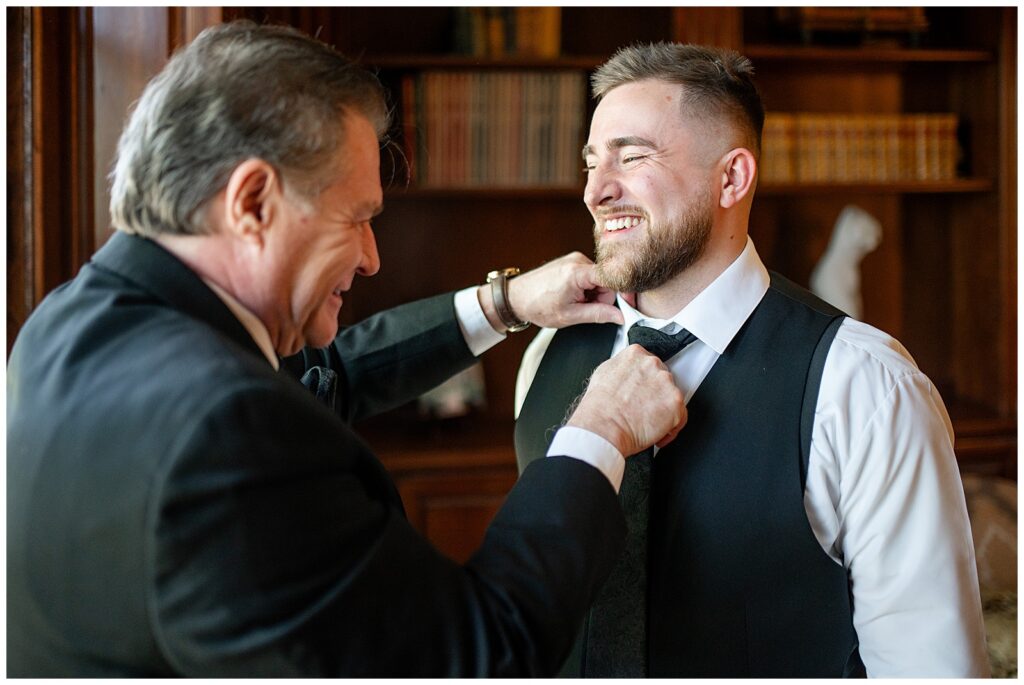 groom's father adjusting his black tie before wedding at domaine pterion