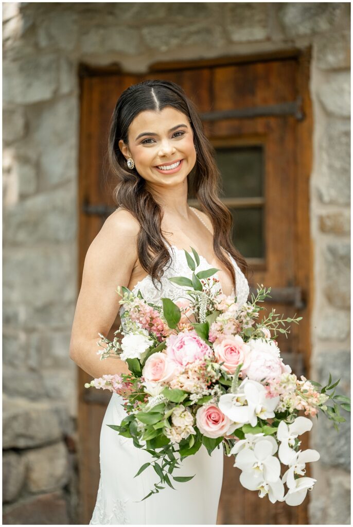 bride smiling at camera holding her large bouquet of flowers in pennsylvania