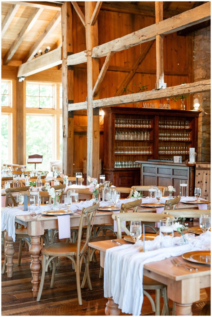 photo of tables beautifully decorated inside wooden barn at domaine pterion