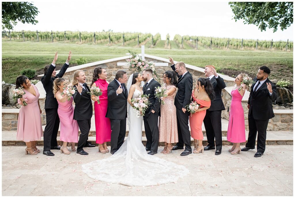 couple kissing as they're surrounded by their cheering bridal party in lehigh county