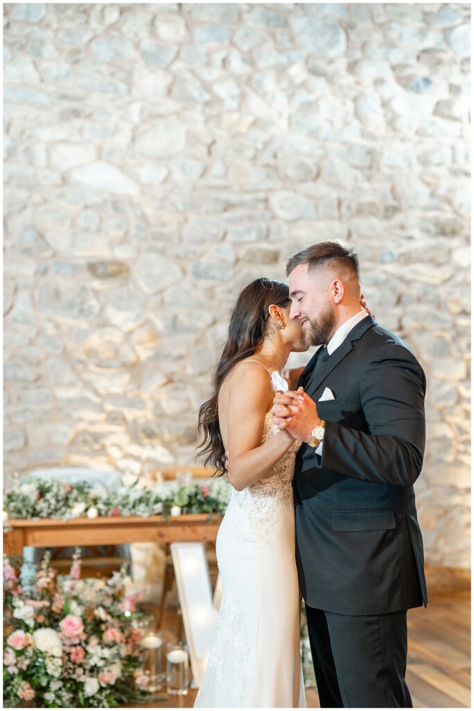 bride and groom sharing their first dance during reception inside stone barn at domain pterion