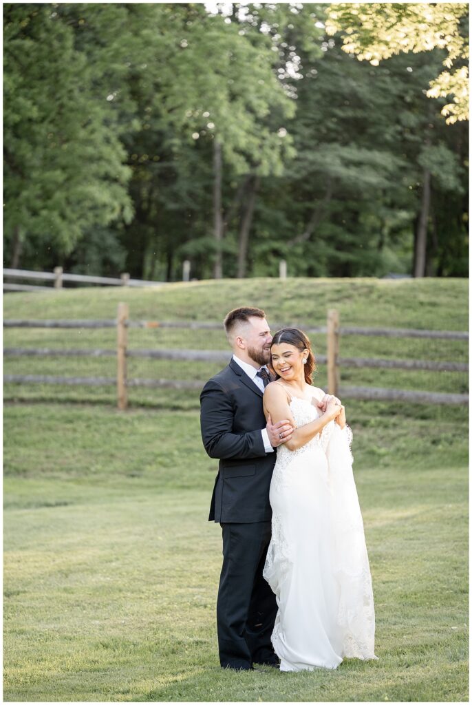 groom hugging his bride from behind in yard at domain pterion