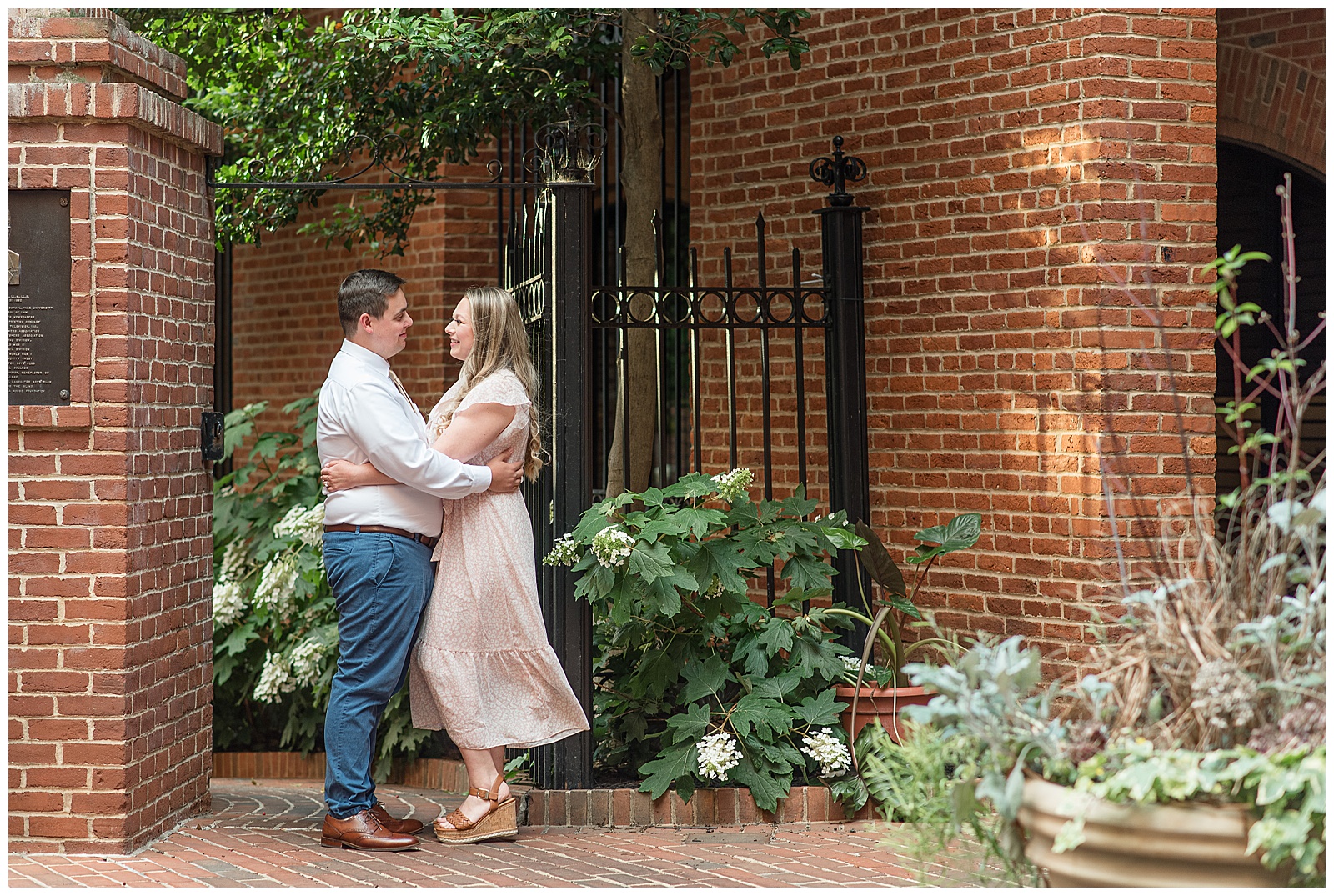 engaged couple hugging by black gate of steinman park in lancaster city