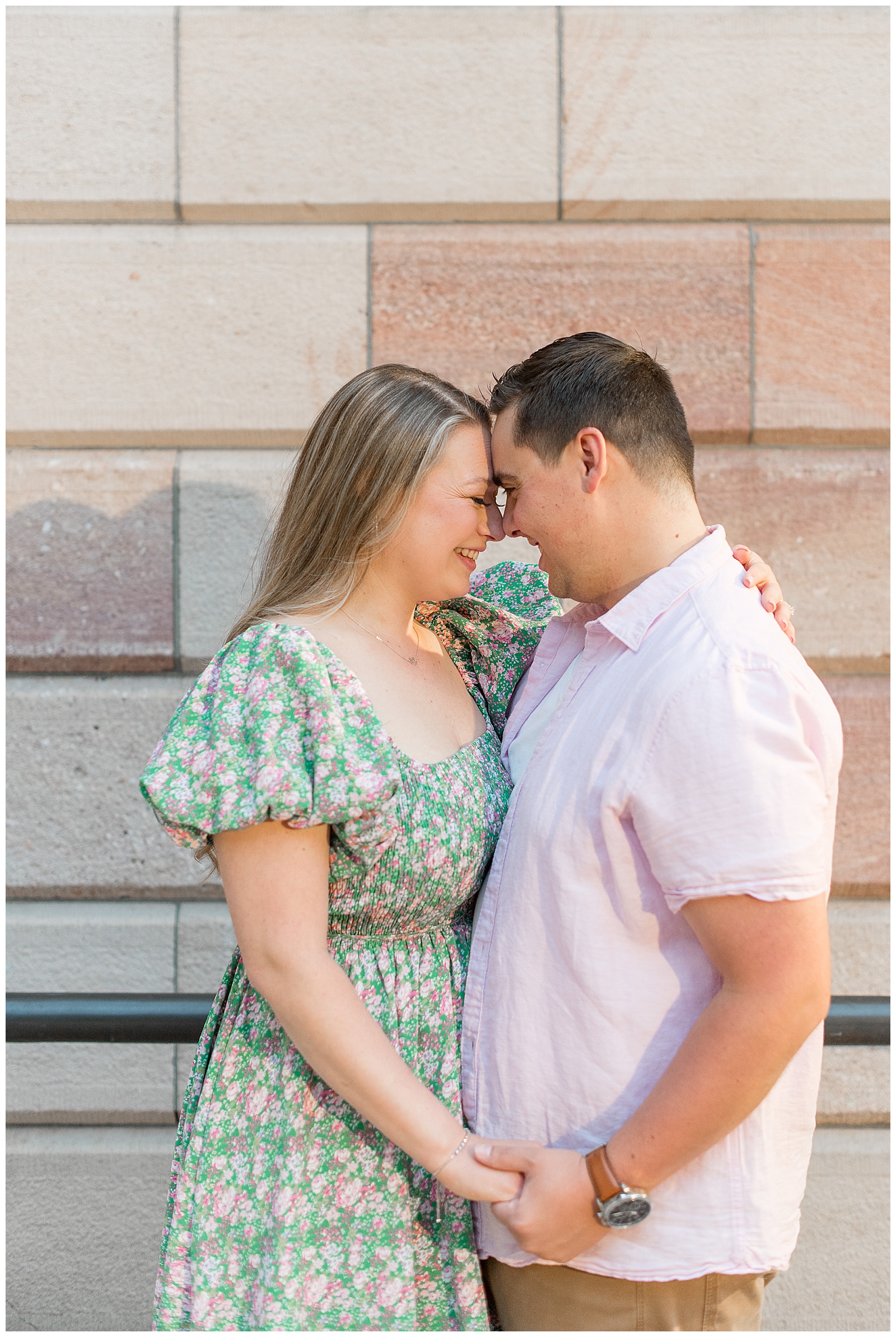 engaged couple touching foreheads as they smile on steps of courthouse in lancaster pennsylvania